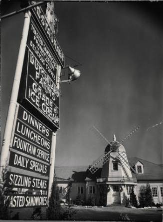 Electric sign in front of restaurant featuring Dutch windmill