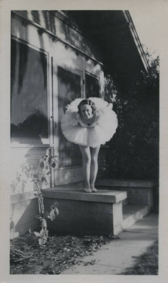 Untitled [Woman in tutu stands on ledge, leans forward]