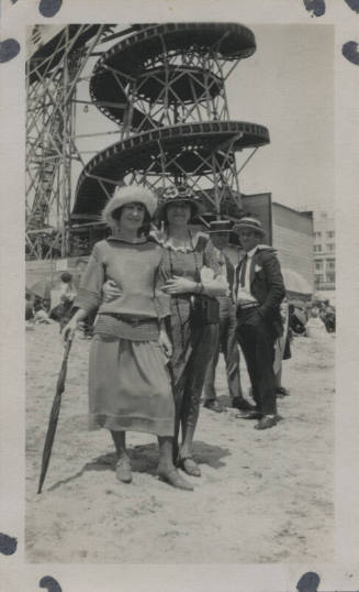 Untitled [Two women stand in front of a toboggan, two men stand behind them]