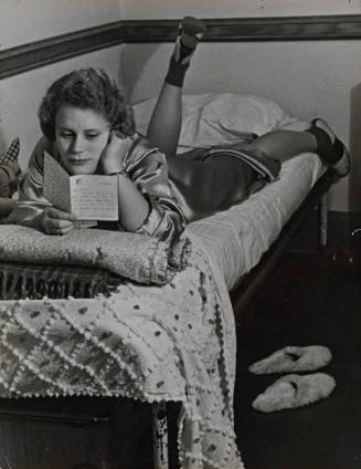 Student (Elizabeth McCain) reading letter on bed, Vassar College
