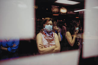 [Woman wearing flag kerchief and dust mask]