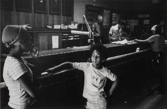 A young boy who says he has been left alone comes to the precinct station house for help. A concerned neighbor looks on