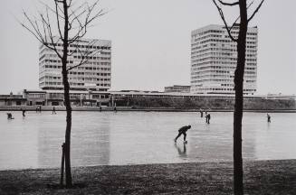 Skaters, Walkers on Frozen Canal with Modern Building in Background, Amsterdam, Holland