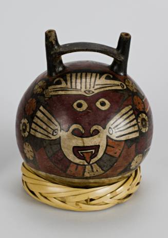 Vessel of globular form with strap handle, twin spouts and a painted feline deity