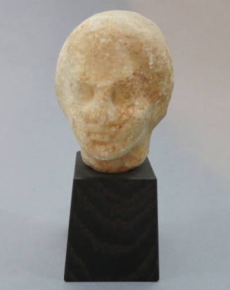 Fragmentary head of youth; head turned to left; weathered