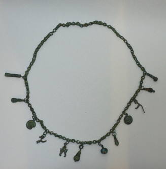 Chain necklace with eleven bronze pendants and one glass pendant