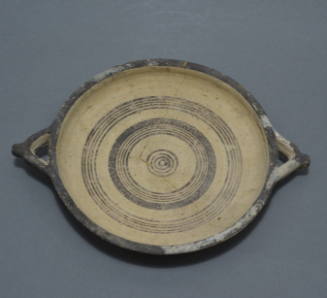 Flat plate white painted ware decorated with circles in brown (interior) and red and brown (exterior); lateral handles