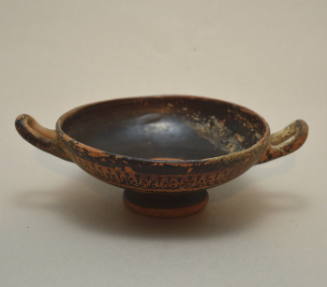 Attic black-glazed kylix with reserved band and frieze of palmettes