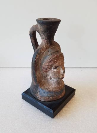 Plastic vase molded in relief with a female head