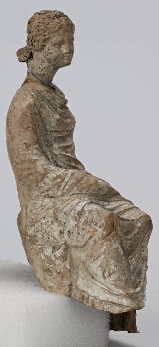 Figure of a woman seated on a rocky outcrop and wearing a himation