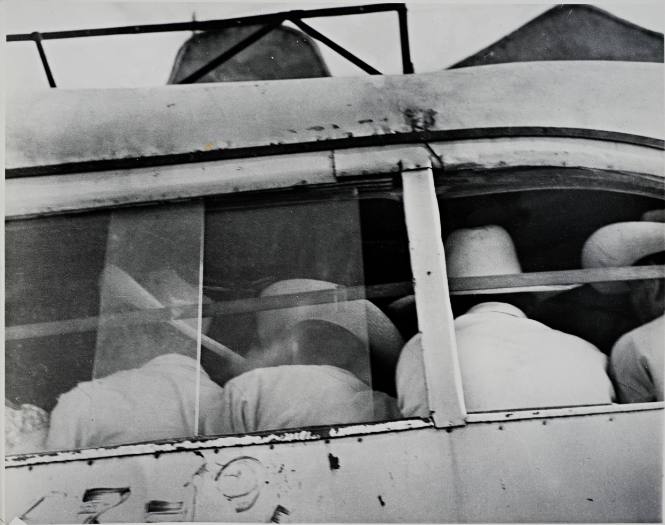 Untitled (Back of seated  men with white hats)