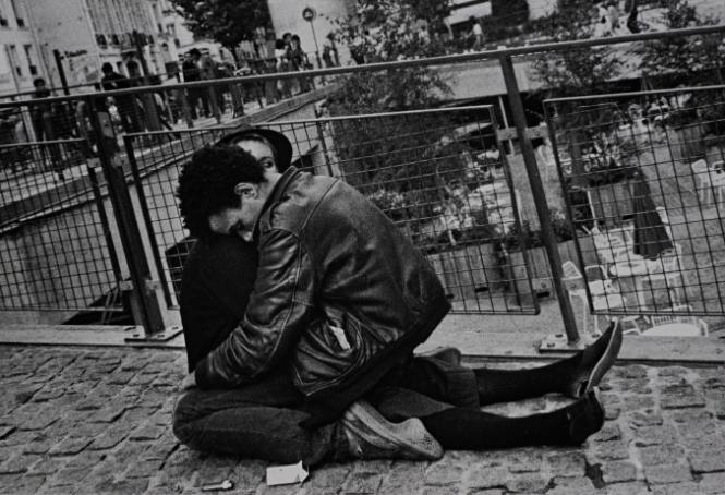Untitled (Young couple sitting on cobblestone street)