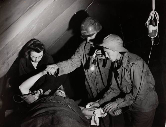 Medic and Army nurses administering blood plasma, Italy