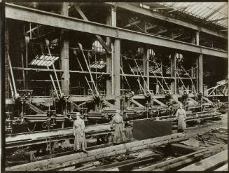 Women operating radial drilling machines, drilling holes in girders (from the British Ministry of Information photographs of women working in factories during WWI)