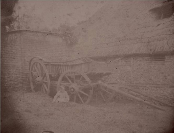 Child Sitting by a Hayrick
