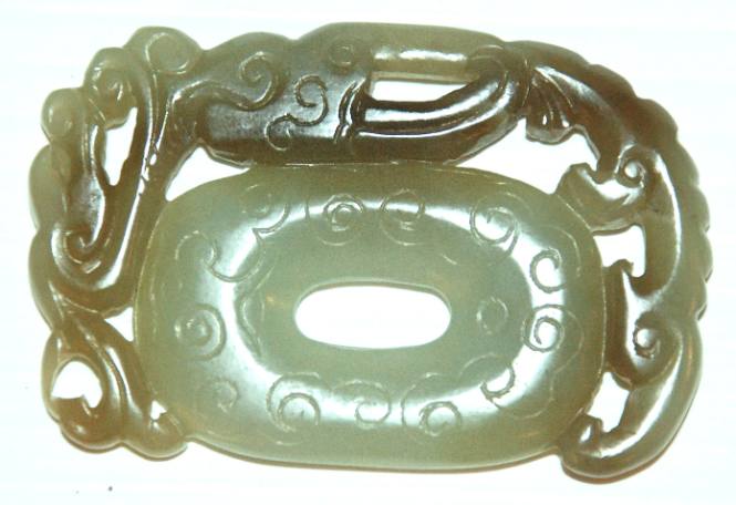 Jade pendant, tassel holder, in form of an oval PI, framed with a reticulated stylized dragon