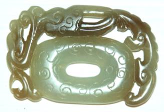 Jade pendant, tassel holder, in form of an oval PI, framed with a reticulated stylized dragon