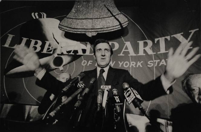 Ed Muskie in front of Liberal Party banner