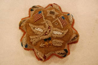Pincushion with star above eagle holding arrow and two American flags