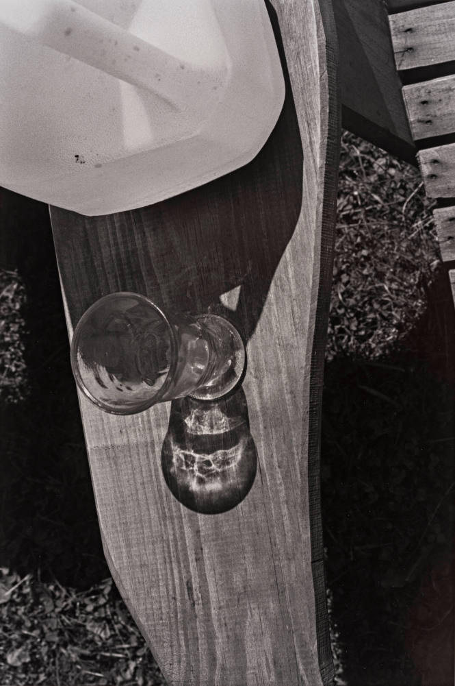Silver Creek Series (close-up of parfait glass and plastic gallon container on arm of wooden chair)