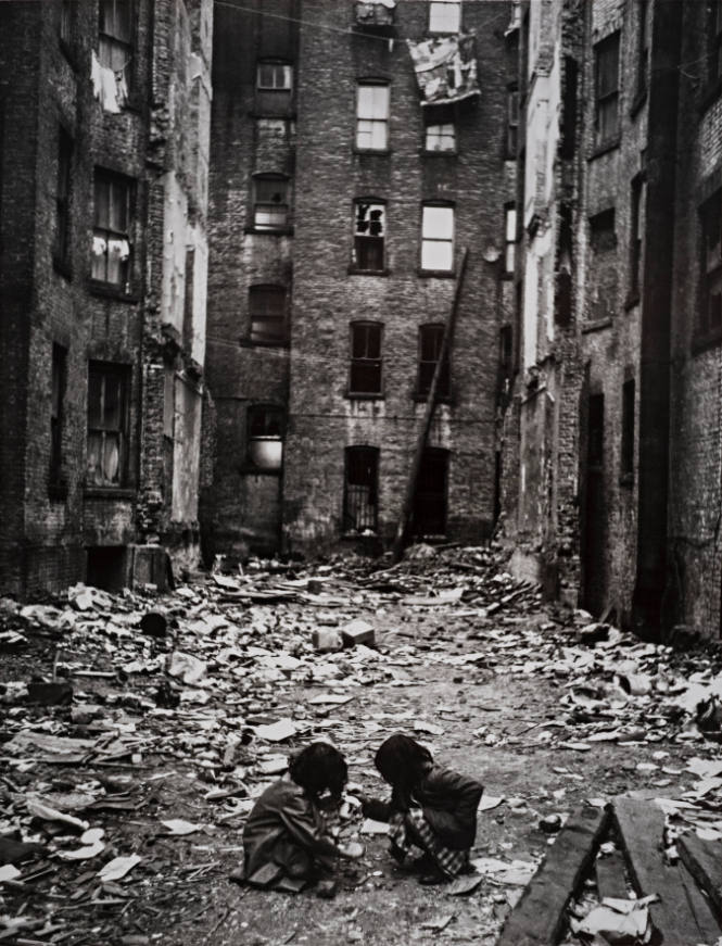 Kids playing amid debris between buildings