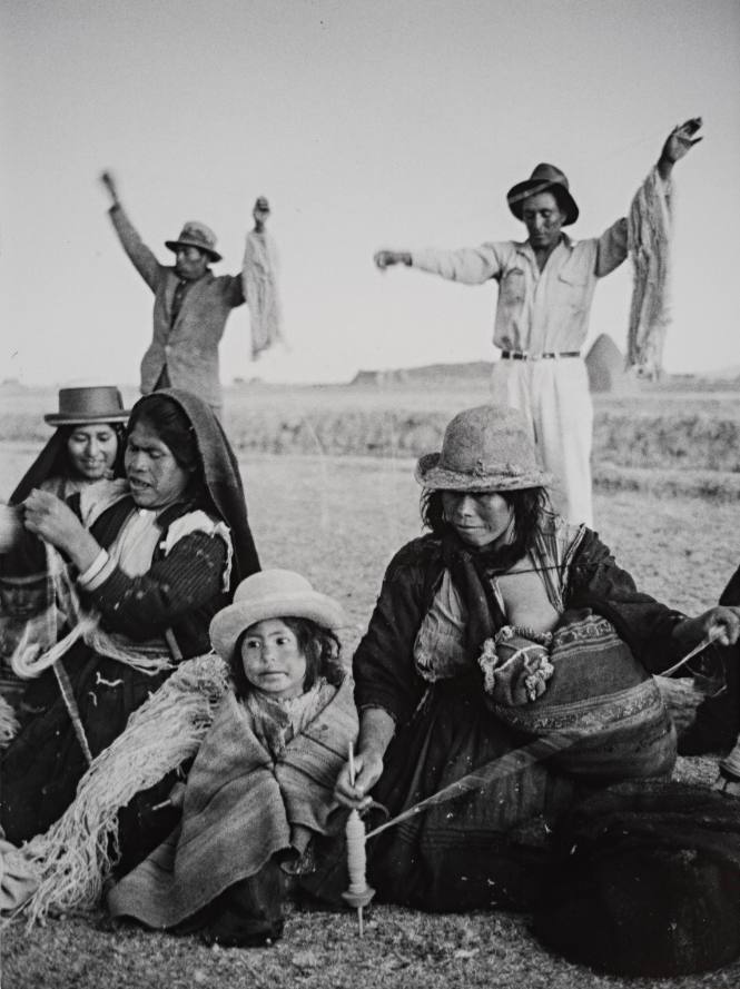 Peru, Cooperative wool factory (Seated women with small girl and men in background)