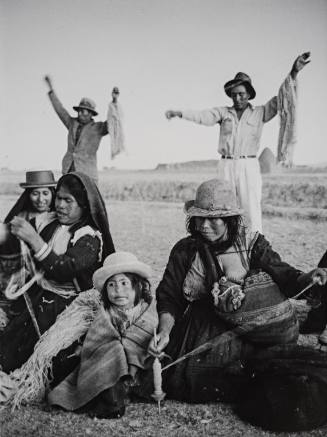 Peru, Cooperative wool factory (Seated women with small girl and men in background)