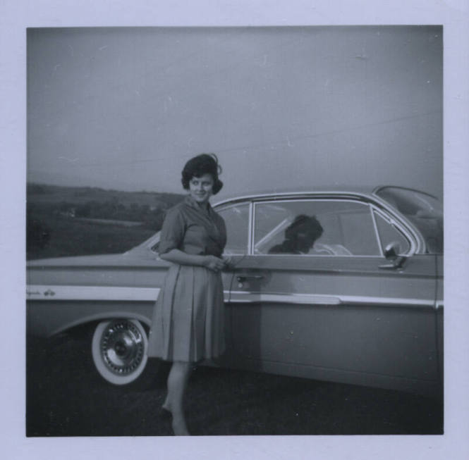Untitled [Woman looks away from car, her shadow as a body on the passenger seat]