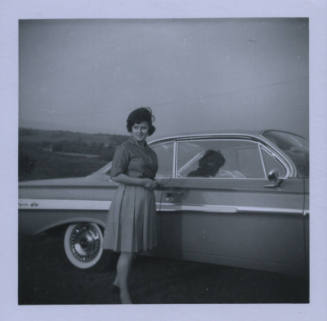 Untitled [Woman looks away from car, her shadow as a body on the passenger seat]