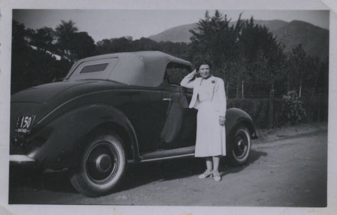 Untitled [Woman dressed in white gown reclines elbow on passenger seat's window]