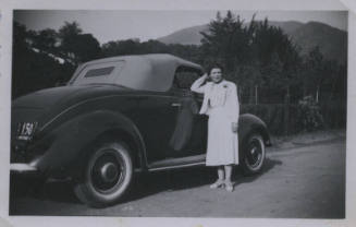 Untitled [Woman dressed in white gown reclines elbow on passenger seat's window]