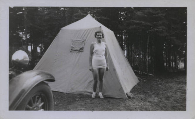 Untitled [Woman stands between car and tent]
