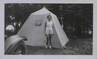 Untitled [Woman stands between car and tent]
