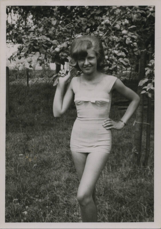 Untitled [Woman holds tree branch, one hand on hip]