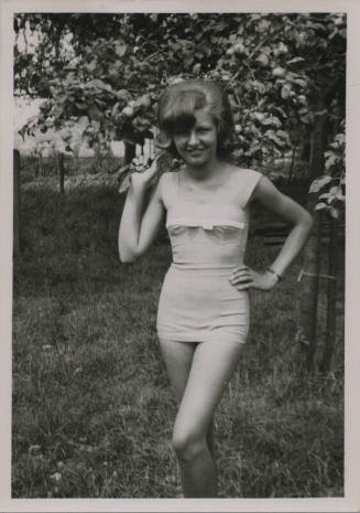 Untitled [Woman holds tree branch, one hand on hip]