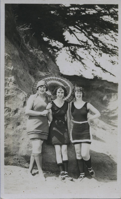 Untitled [Three women stand on a beach with umbrella, wear ballet slippers]