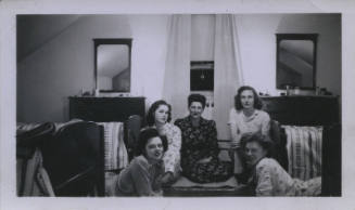 Untitled [Five women sit on room floor, parallel mirrors in the background]