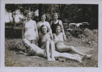 Untitled [Six women in bathing suits sit, lie, and kneel in garden]