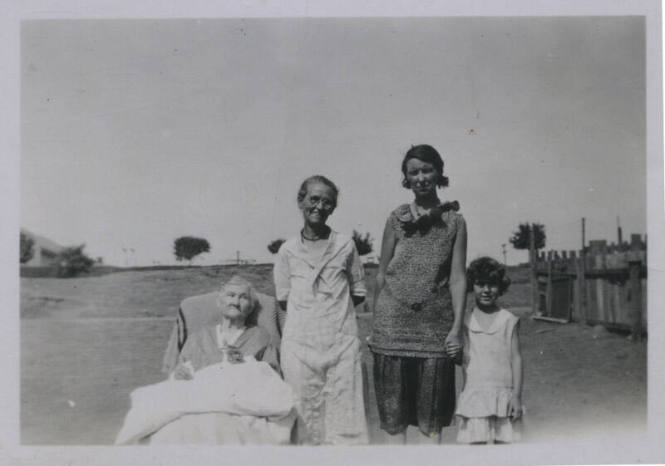 Untitled [Four women stand outside in horizontal line, seemingly oldest to youngest, left to right]