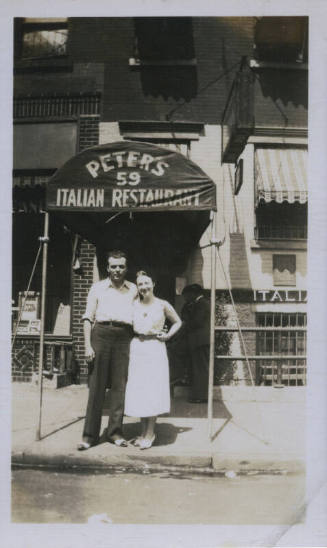 Untitled [Woman and man stand on street, under sign that reads Peter's 59 Italian Restaurant]