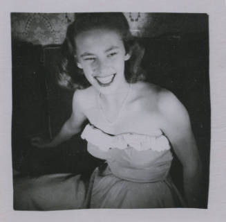 Untitled [Woman sits on couch and smiles widely]