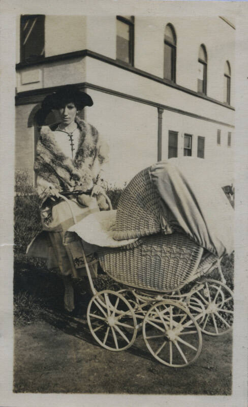 Untitled [Woman stands outside with stroller]