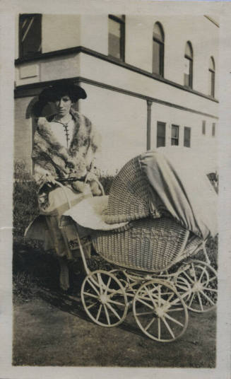 Untitled [Woman stands outside with stroller]