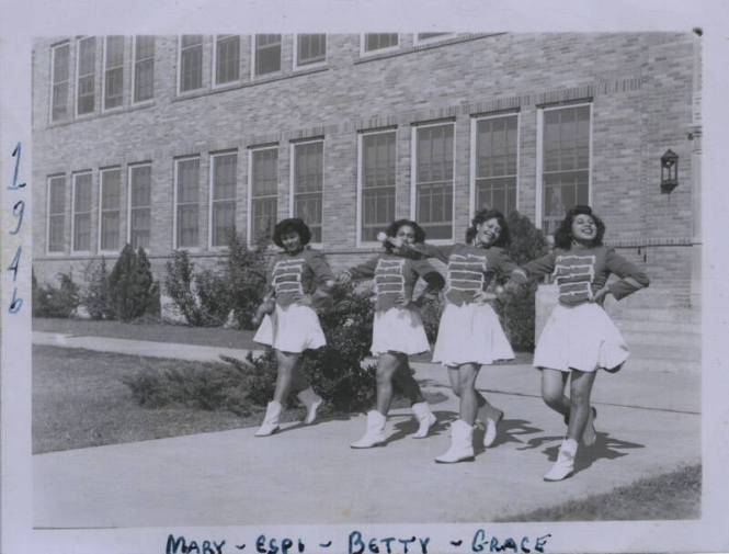 Untitled [Four women in parade attire step forward with hands on hips]