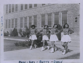 Untitled [Four women in parade attire step forward with hands on hips]