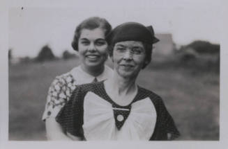 Untitled [Two women stand on a field, one in front of the other]