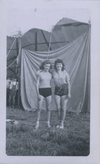 Untitled [Two women stand in front of a tent, boy in background]