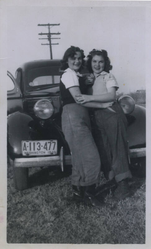 Untitled [Two women embrace in front of car whose plates read A-113-477 Washington 1940]