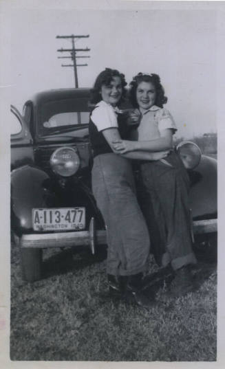 Untitled [Two women embrace in front of car whose plates read A-113-477 Washington 1940]