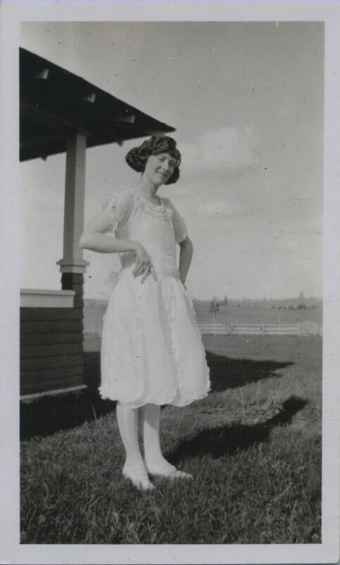 Untitled [Woman stands on field, hands on hips]
